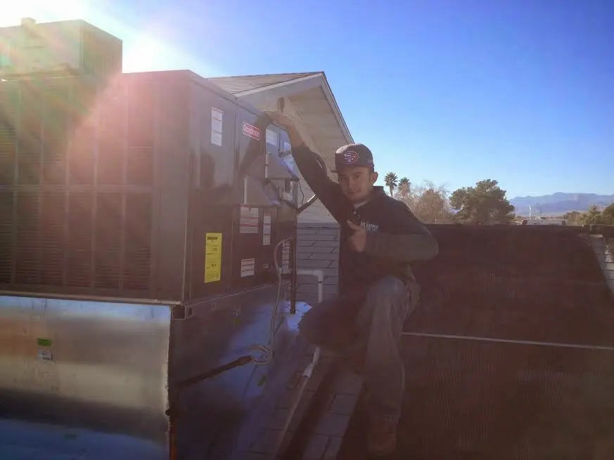 HVAC technician performing HVAC Inspection on a rooftop unit in Crowley